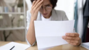 A-woman-with-glasses-angrily-and-worridly-reads-a-letter