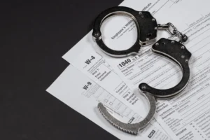 An_Image_of_Handcuffs_Superimposed_Over_Tax_Forms_Represents_the_Recent_Conviction_of_Barry_Lee_White_for_Failure_to_Pay_Federal_and_Payroll_Taxes_The_Daily_Muck