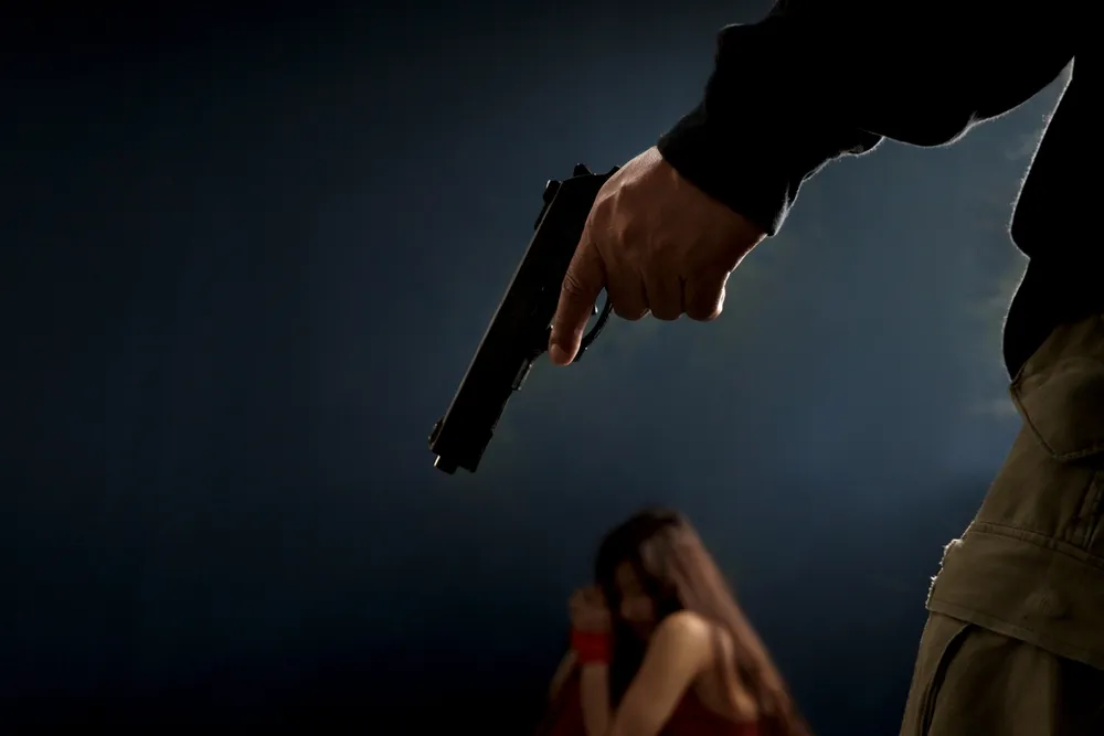 The_Silhouette_of_a_Man_Holds_a_Pistol_and_in_the_Background_a_Woman_Cowers_Representing_Domestic_Gun_Violence_Awareness_Campaign_by_the_DOJ_The_Daily_Muck