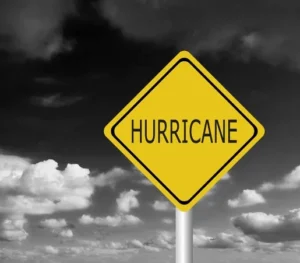 Clouds Against a Dark Sky and a Sign that Says Hurricane in Yellow Represents the INcreasing Dangers of the Storms in Florida - The Daily Muck