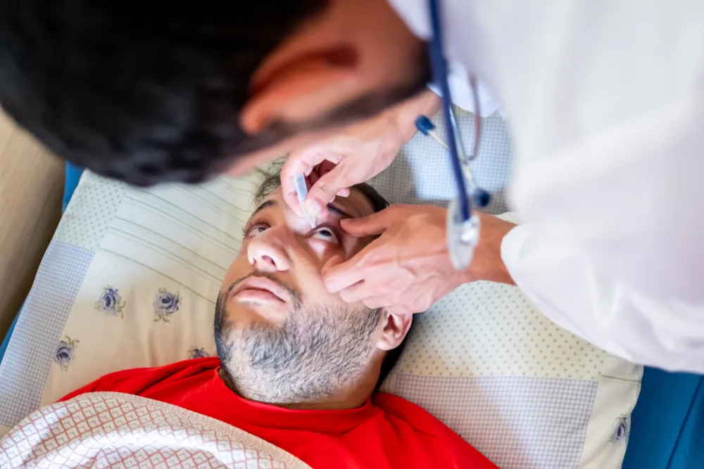 An_Eye_Doctor_Puts_Drops_in_the_Eyes_of_a_Worried-Looking_Patient