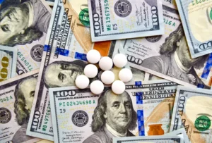 Pills_On_Top_of_Hundred_Dollar_Bills_Represent_the_Problem_of_Online_Pharamcies_Making_Illicit_Gains_By_Selling_Counterfeit_and_Unapproved_Drugs