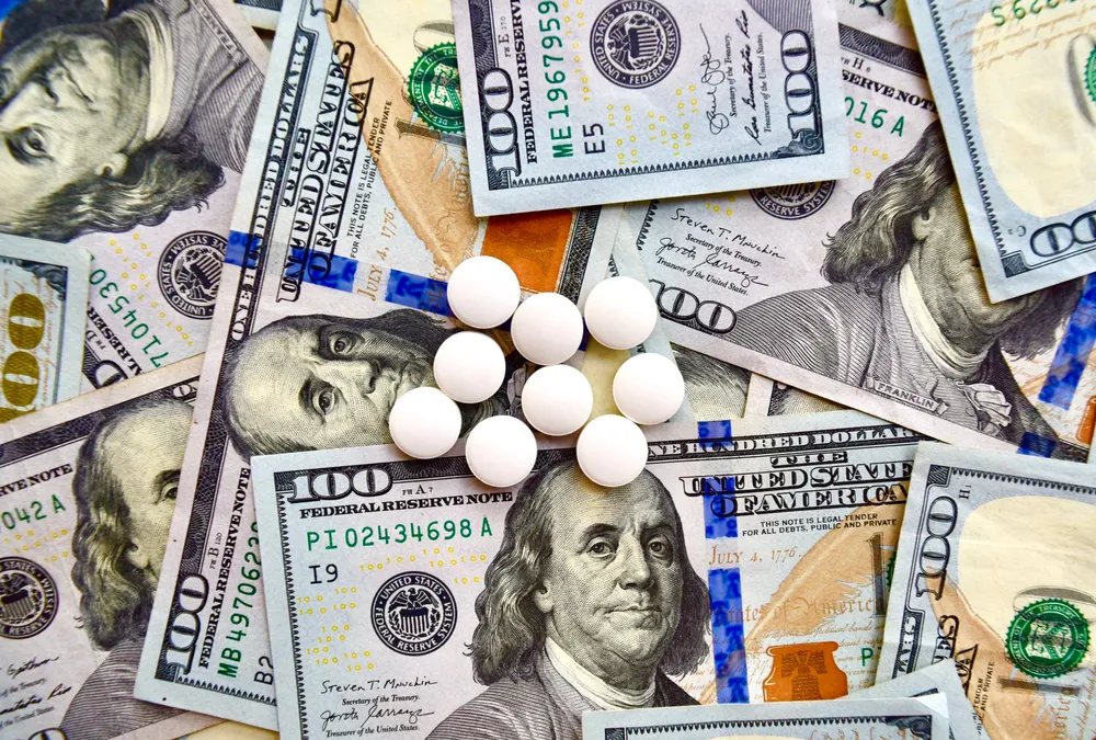 Pills_On_Top_of_Hundred_Dollar_Bills_Represent_the_Problem_of_Online_Pharamcies_Making_Illicit_Gains_By_Selling_Counterfeit_and_Unapproved_Drugs