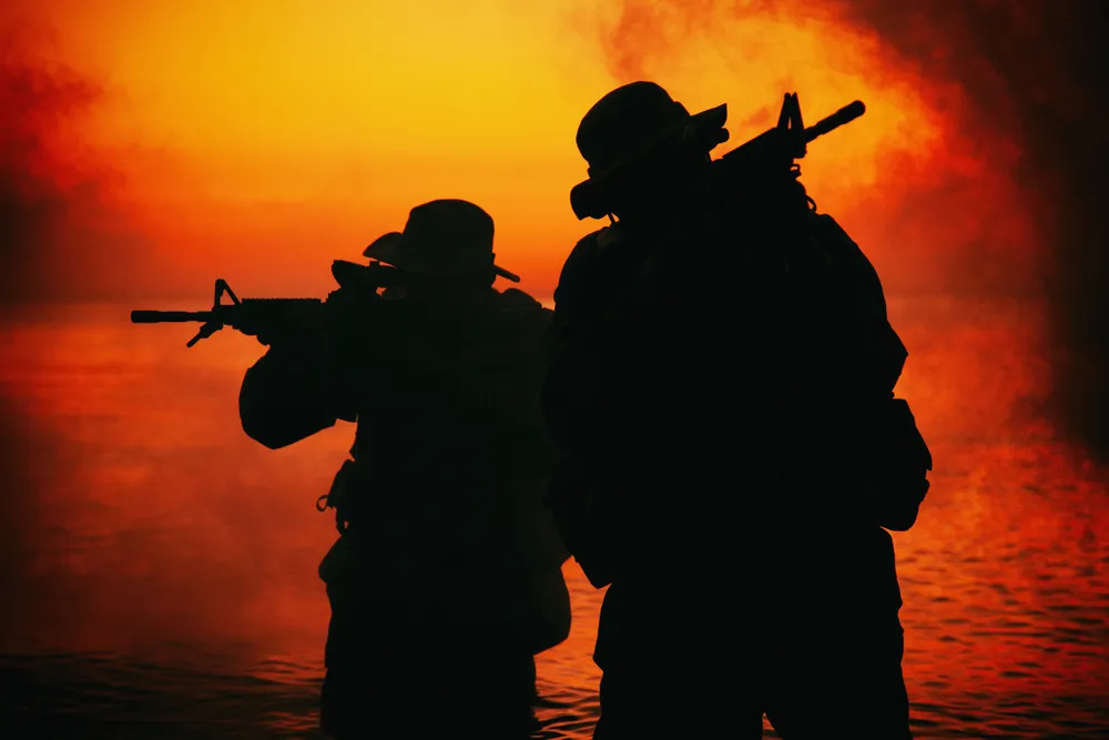 The_Silhouette_of_Two_Commandos_Pointing_Rifles_Represents_Saint_Jovite_Youngblood_a_Man_Who_Ripped_HIs_Victims_Off_For_Millions_By_COnvincing_Them_They_Were_Being_Targeted_by_Cartels