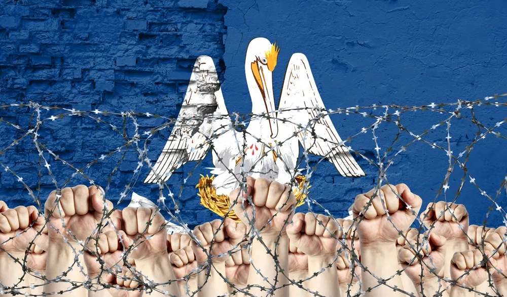 A_Pelican_Over_a_Background_of_a_Blue_Prison_Wall_and_Barbed_Wire_with_Raised_Fits_Represents_the_Troubled_Louisiana_Prison_Sentences_Which_Feds_Day_Does_Not_Release_Prisoners_in_a_Timely_Manner