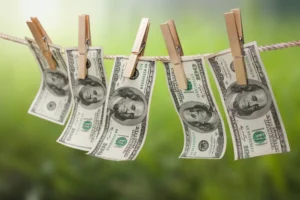 Three_Russian_Cryptomixers_Have_Been_Charged_With_Money_Laundering_As_Representing_By_a_Clothesline_and_Clothespin_Holding_Up_100_Dollar_Bills